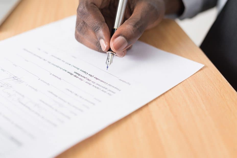 hand signing a contract — generic visual to illustrate how escrow fits into the transaction process. 